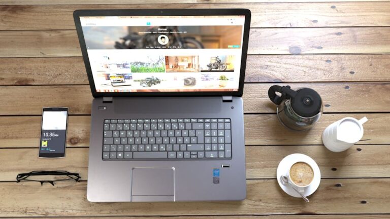 Web designing company Top view of a laptop, smartphone, coffee, and glasses on a wooden desk.