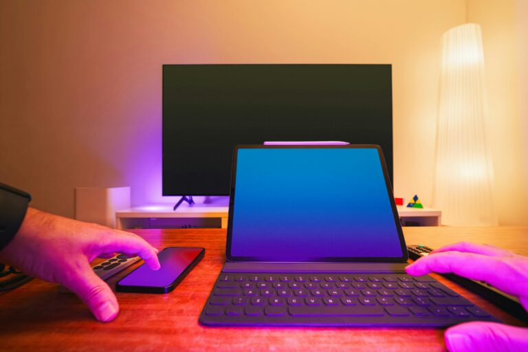 web design & development company A vibrant workspace featuring a laptop, tablet, and TV with colorful lighting.
